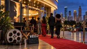 Illustrative view of Black filmmakers and moviegoers entering a Houston cinema for a film festival, with a red carpet, film equipment and the city skyline.